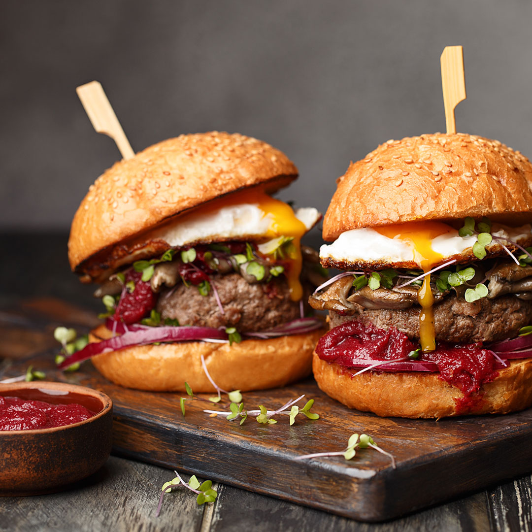 Gourmet breakfast burgers cooked on a griddle plate