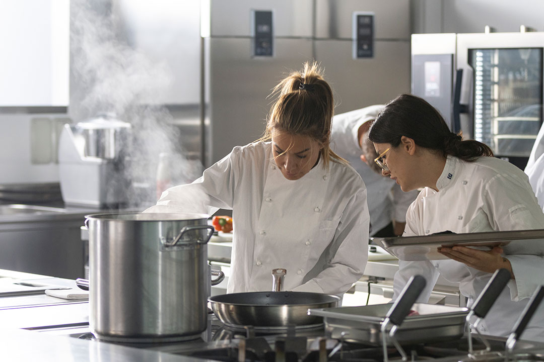 Chef cooking on induction equipment in a commercial kitchen environment
